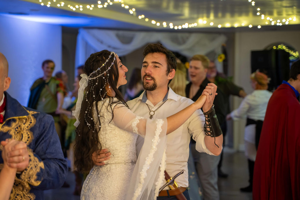 A couple dancing in the ballroom beneath fairy lights