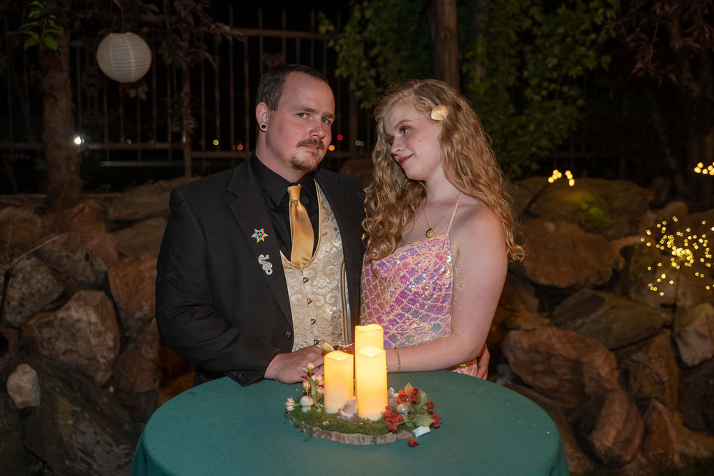 A couple beside a candlelit table in the garden