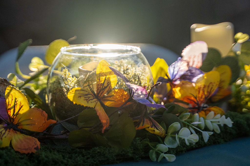 Floral centerpiece with butterflies and a floating candle