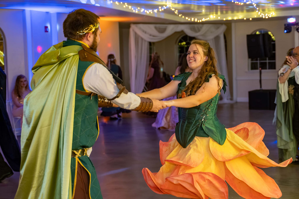 A couple dancing, her flame-colored gown swirling